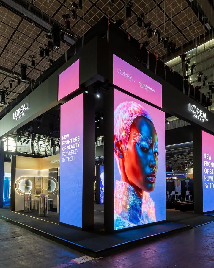 L'Oréal exhibition booth showcasing new frontiers of beauty powered by tech, featuring vibrant displays and innovative skincare products for top beauty brands 2025.