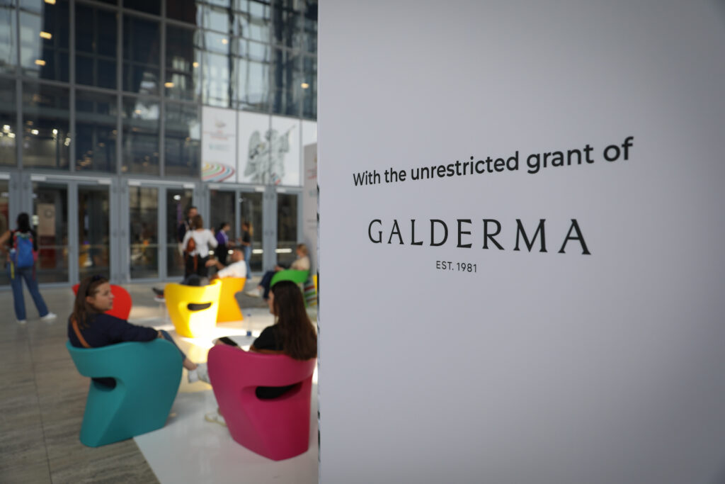 Galderma event with vibrant seating and branding sign, showcasing dermatology innovation since 1981.